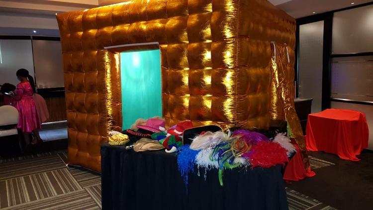 Gold inflatable photo booth set up at an indoor event